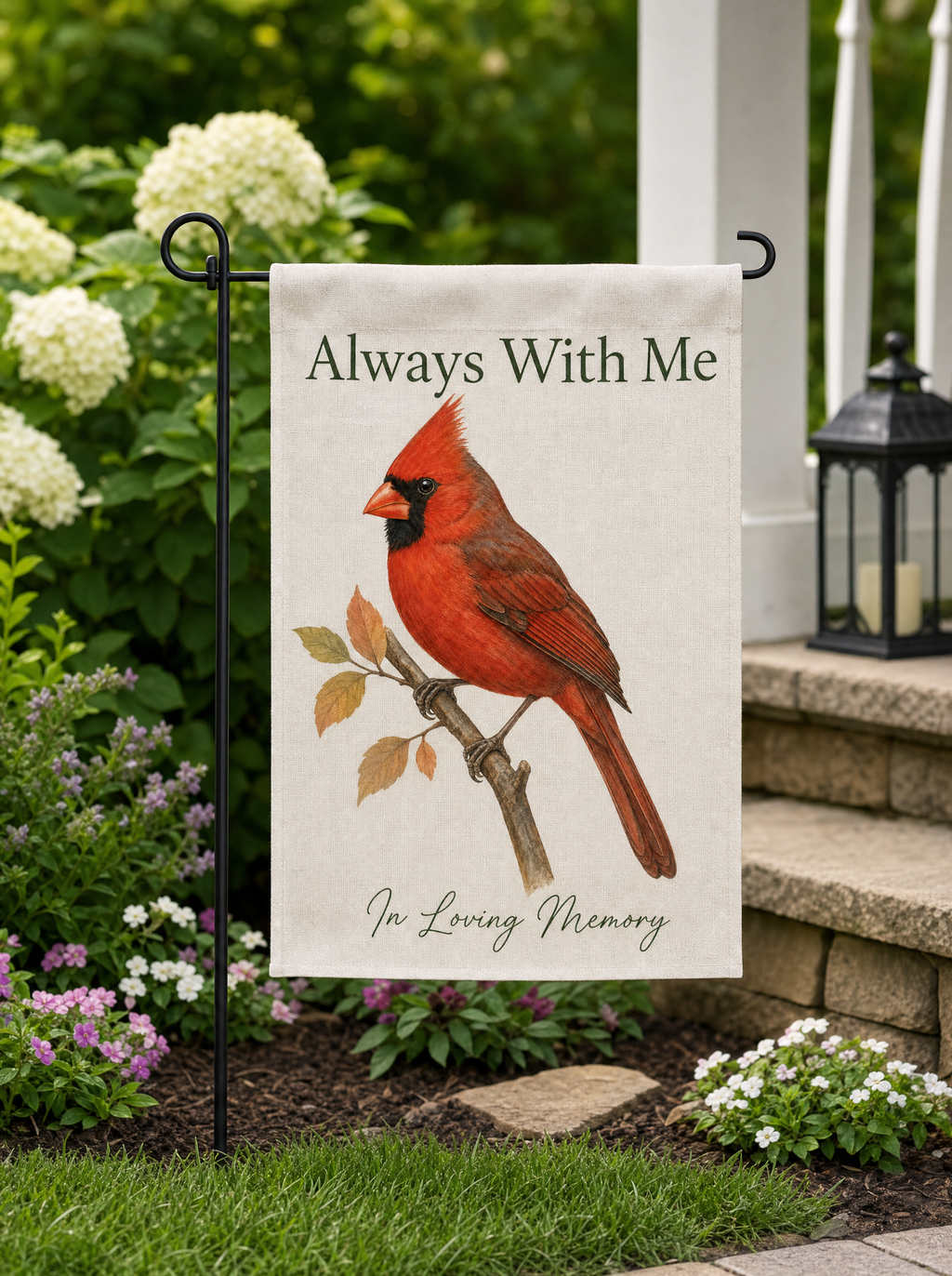 Cardinal memorial garden flag Always With Me in a flower bed by the porch