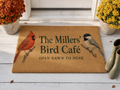 Personalized Bird Café doormat on a porch with mums